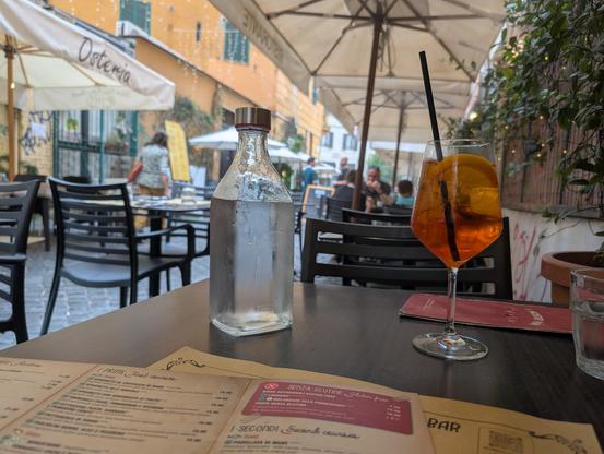 Aperol Spritz on a table in an alley in Roma.