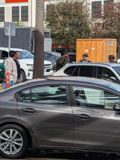 Bearded SFPD officer in charge looks confused. Man in plaid with green jacket was driver.